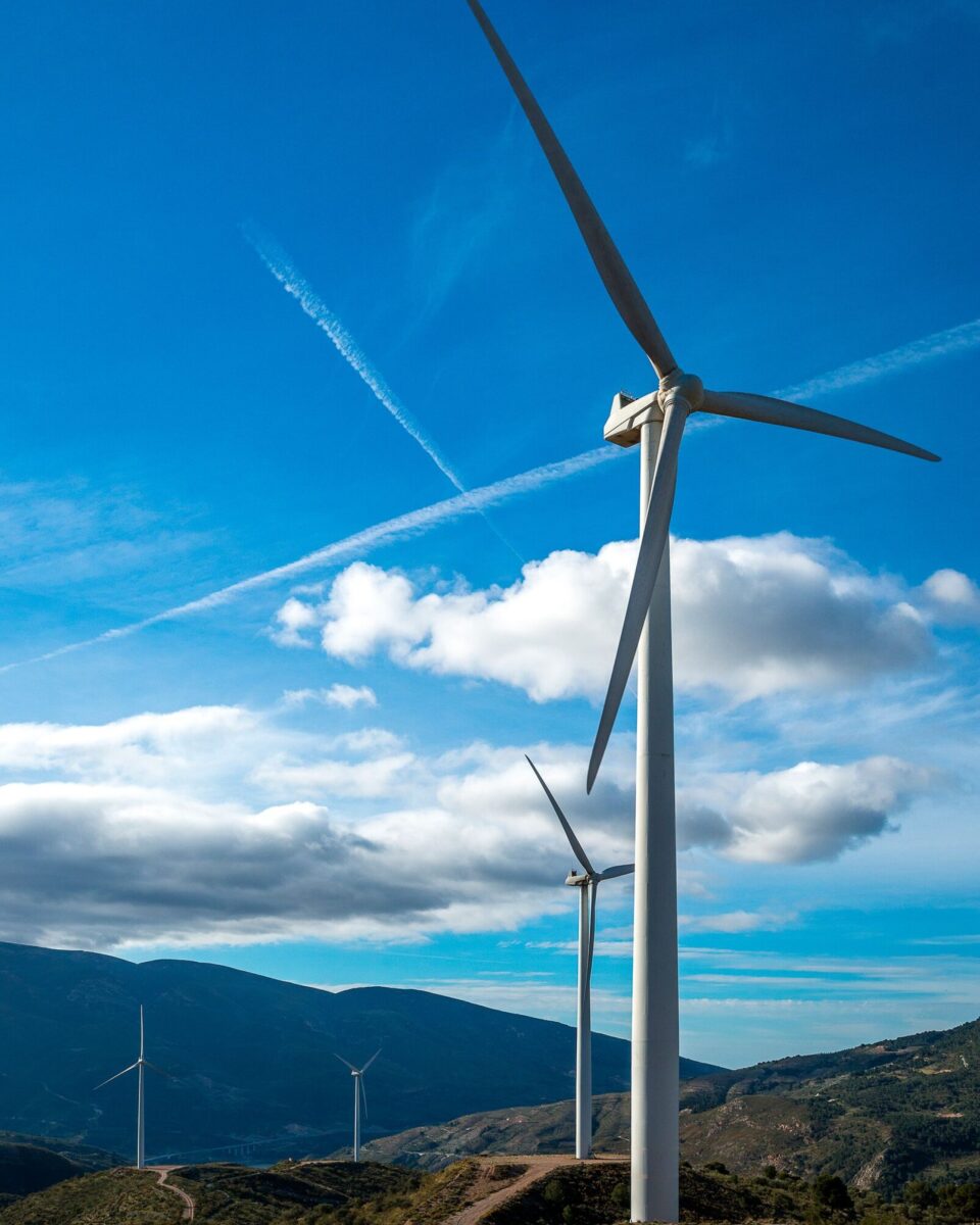 vertical-shot-several-white-electric-windmills-hill